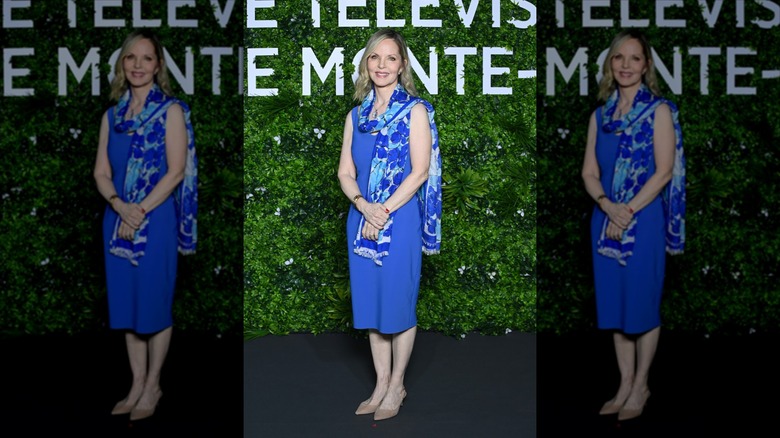 Melissa Sue Anderson smiles wearing a colbalt blue midi dress and a colbalt blue and light blue scarf