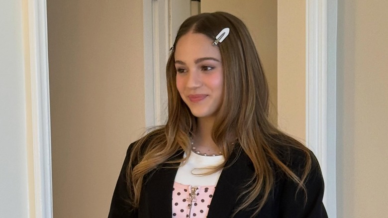 Skywalker Hughes wearing a black jacket with a black-and-pink polka dot shirt and clips in her hair.