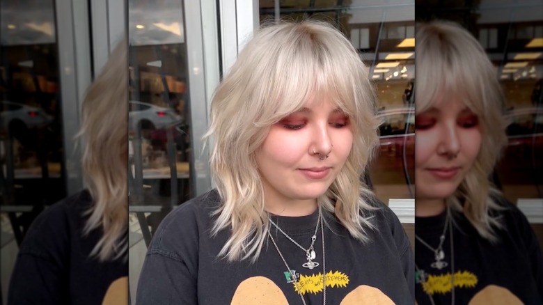 A woman with a blond shag and curtain bangs