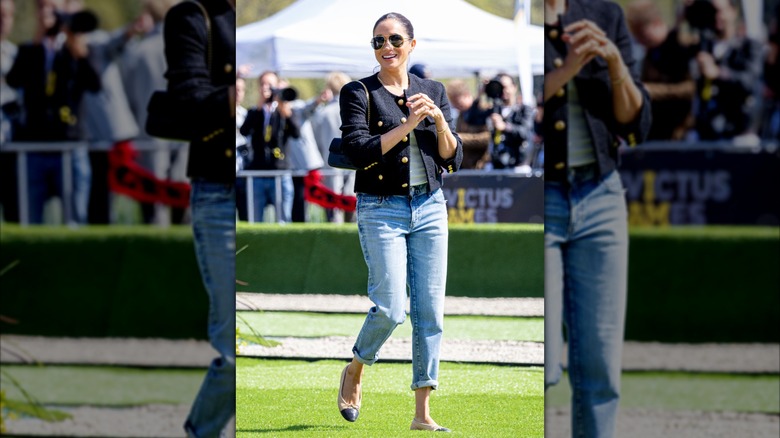 Meghan Markle wearing black tweed jacket with light wash jeans and Chanel ballet flats.