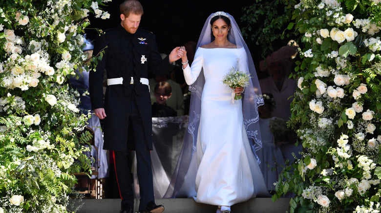 Meghan Markle pictured with Prince Harry wearing a white long-sleeved wedding dress
