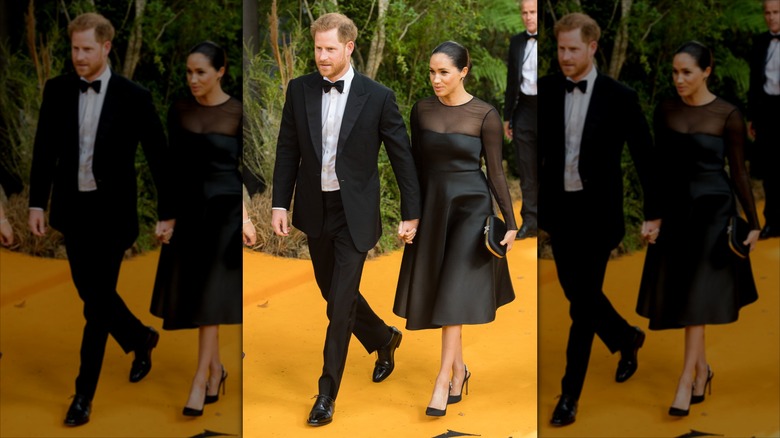 Meghan Markle wearing a black A-line dress next to Prince Harry wearing a suit