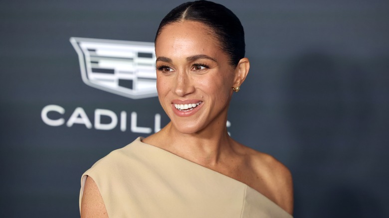 Meghan Markle wearing a one-shoulder beige dress