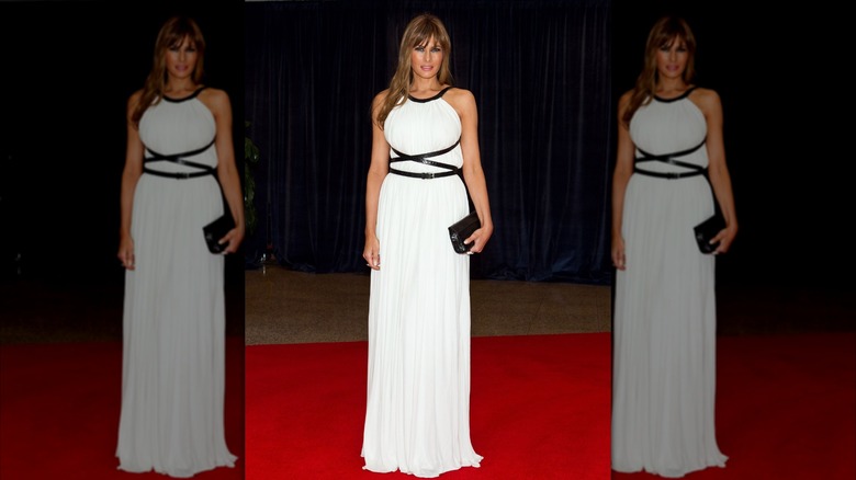 Melania Trump wears a white dress while posing for photos