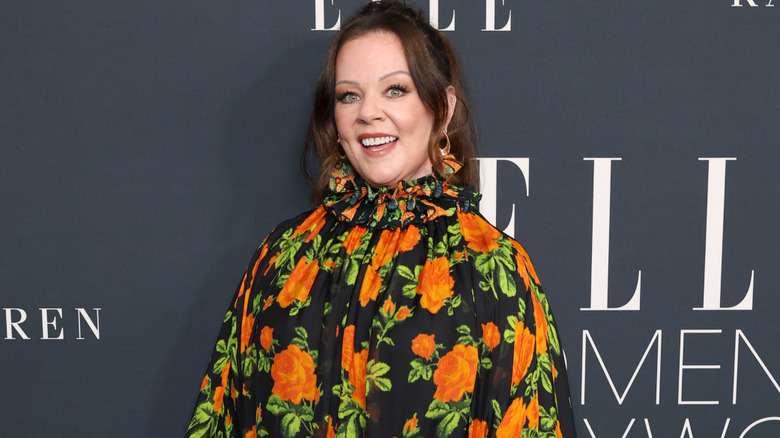 Melissa McCarthy poses for a photo while wearing a floral dress