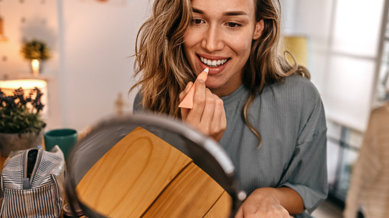 Woman applying lip balm