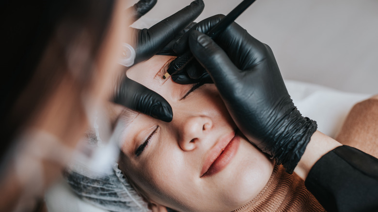 smiling woman undergoing microfeathering procedure