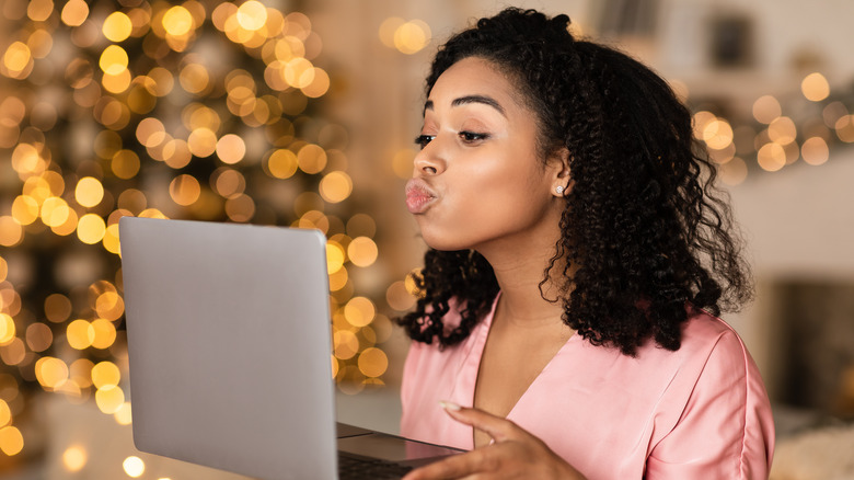 Woman kissing computer 