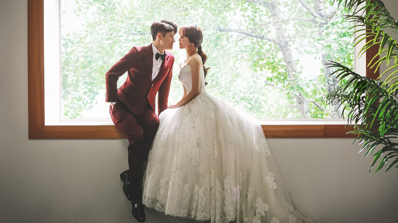 newlyweds sitting on window