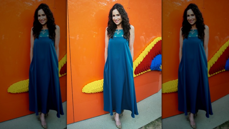 Minnie Driver at an event wearing a loose blue dress with her hair half up half down.