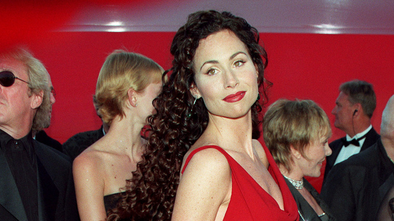 Minnie Driver posing in a red dress on the 1998 Academy Awards red carpet.