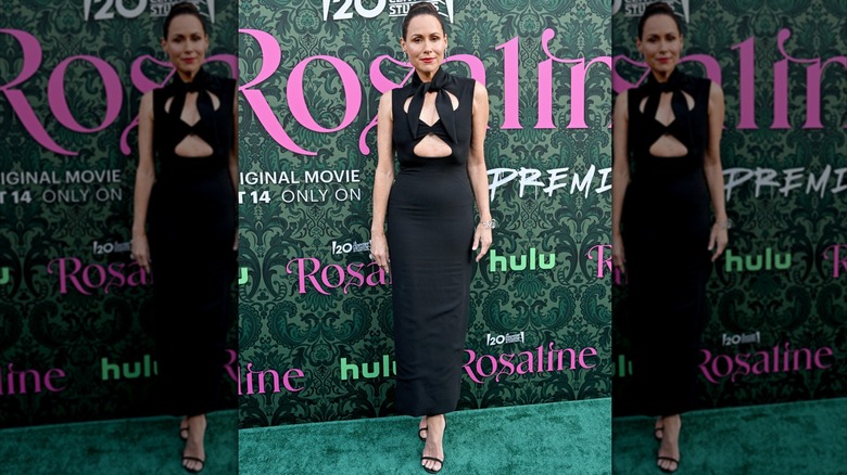 Minnie Driver posing at a premiere wearing a black dress with cutouts around the chest.