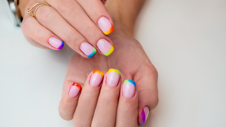 person with rainbow tip manicure