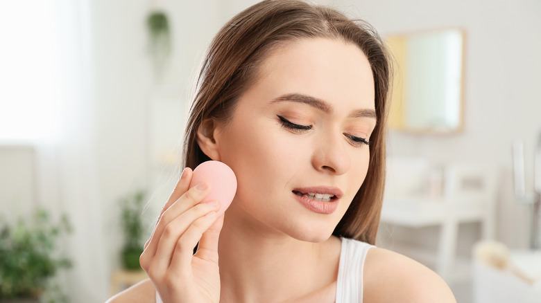 women blending foundation with a sponge