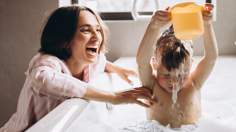 mom bathing son in bathtub