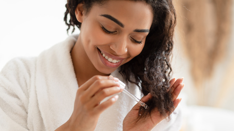 Woman applying oil to her hair