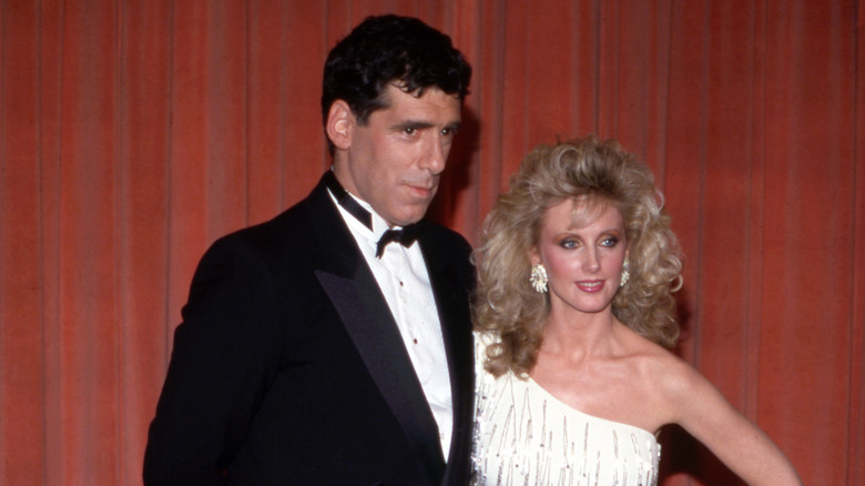 Elliot Gould in a tuxedo and Morgan Fairchild in a white gown posing at the 1983 Academy Awards.
