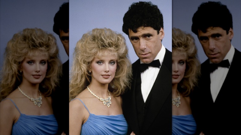 Morgan Fairchild in a blue dress and diamond necklace and Elliott Gould in a tuxedo at an awards show.