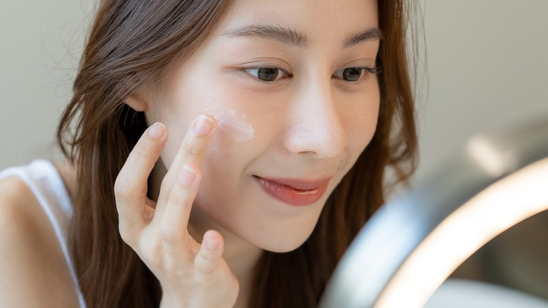 woman apply makeup cream 