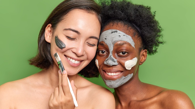 two woman applying face masks