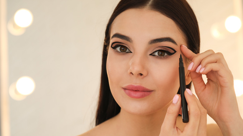 woman applying eyeliner