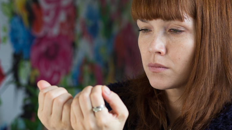 woman looking at her nails 