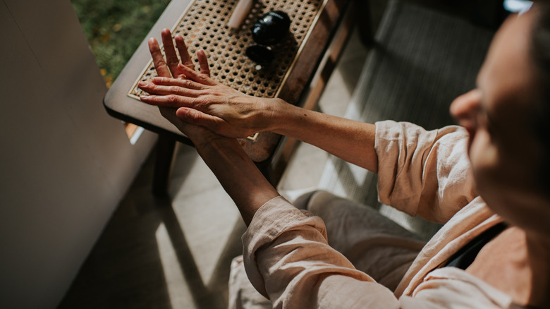 A woman rubbing cream into her hands.