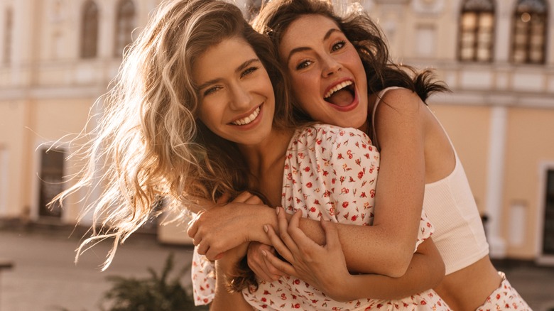 two smiling women hugging each other