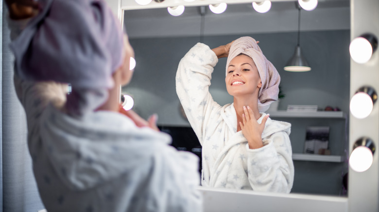 Woman checks neck in mirror