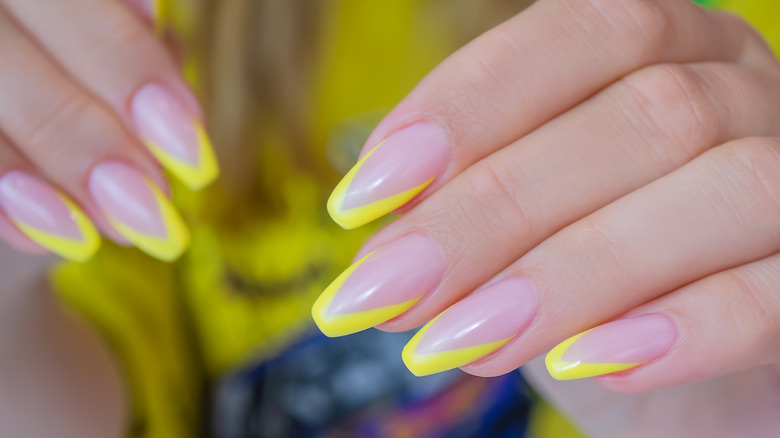 Premium Photo | Manicure with trendy yellow color of nail polish on female  hands. minimal design.