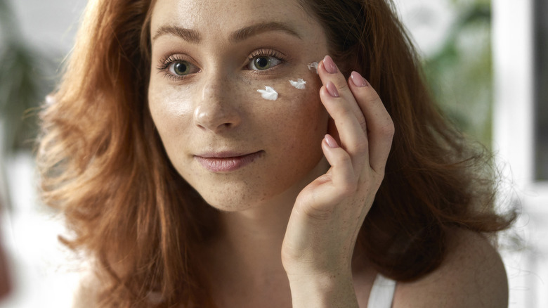 woman applying skincare product