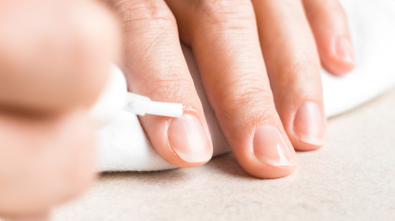 Woman applying cuticle oil