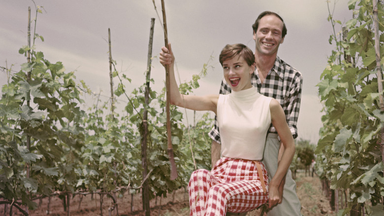 Mel Ferrer pushing Audrey Hepburn on a swing in a vineyard