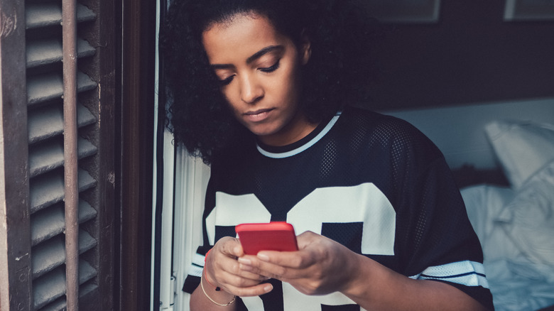 Unhappy woman using cell phone