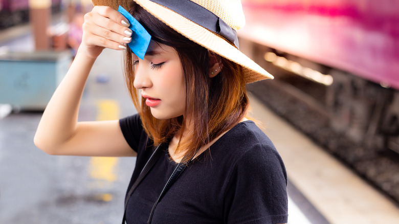 woman blotting oil on face