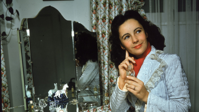 Elizabeth Taylor applying perfume