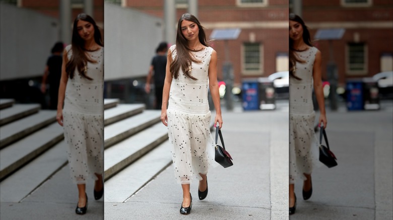 A woman wearing a white drop-waist dress.