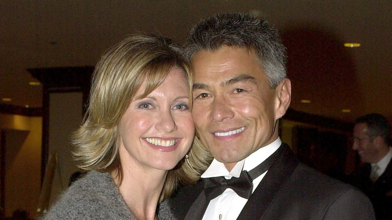 Olivia Newton-John rocks a fringe bob haircut while posing with her face against that of her former boyfriend, Patrick McDermott.