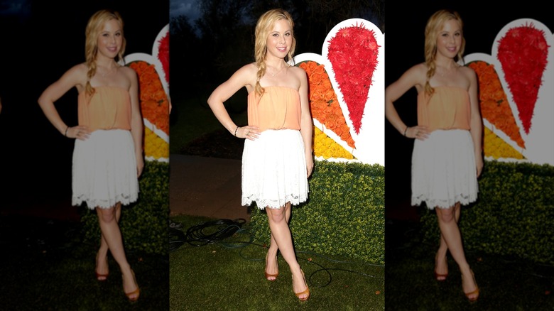 Tara Lipinski in a white skirt and orange strapless top