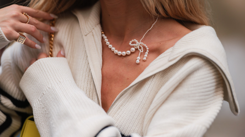 Girl wearing pearl bow necklace.