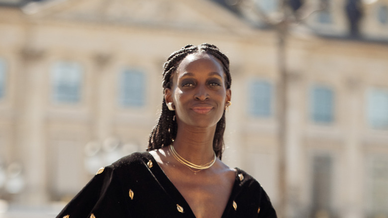 A guest wears a chic black mini dress and a layered necklace aT Paris Fashion Week for FW 2026/2027