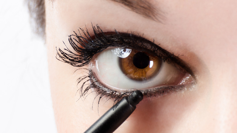 woman applying eyeliner