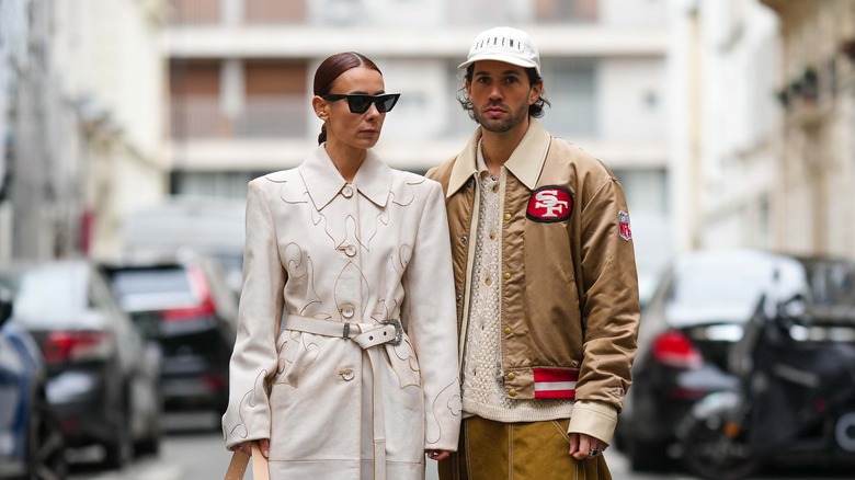 Woman poses in trench coat with shoulder pads in Paris 