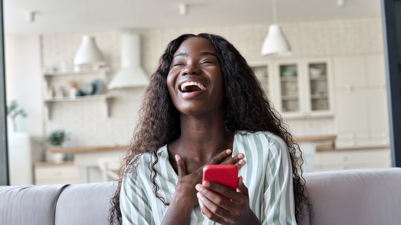 Happy woman reading a dating app