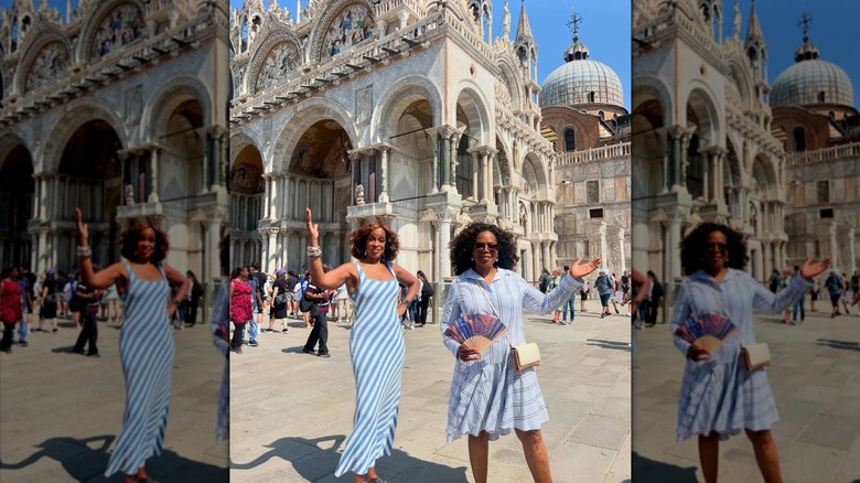 Gayle King and Oprah Winfrey pose in front of a landmark wearing stripe dresses