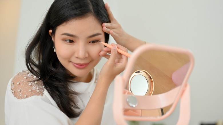 woman applying eyeliner