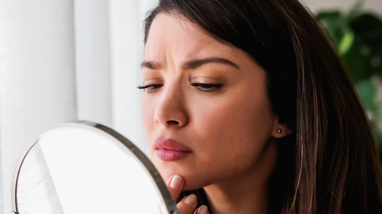 Woman frowning in mirror