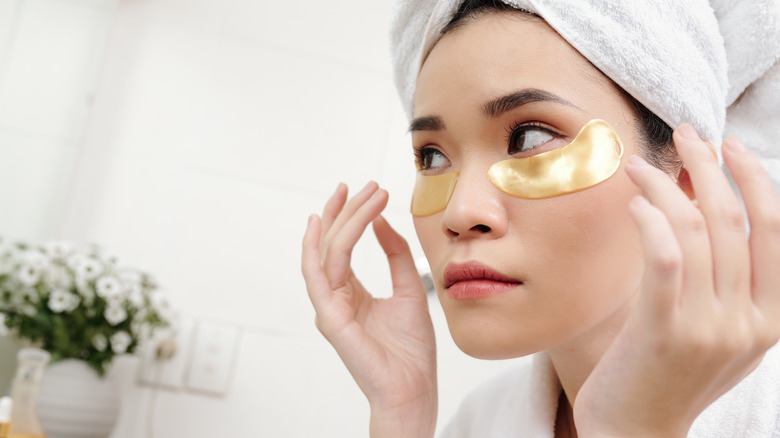 woman placing eye masks on