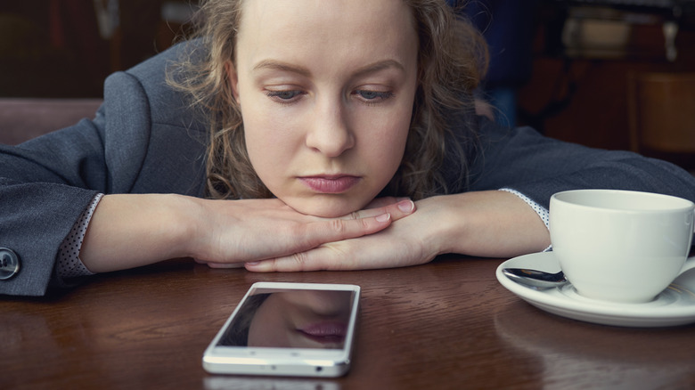 woman staring at phone