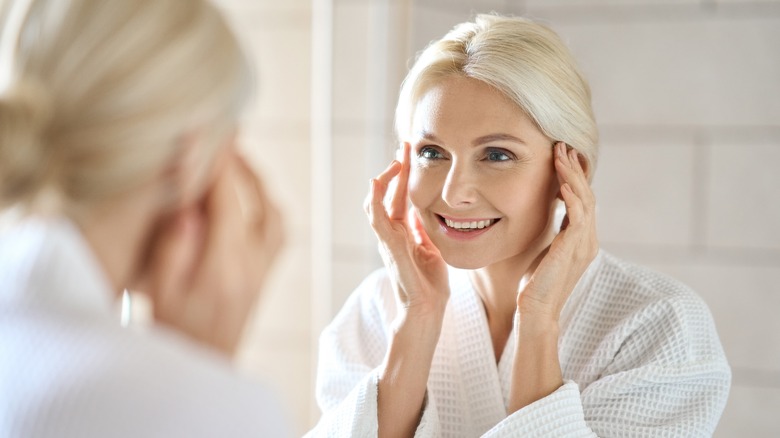 Mature woman looking in mirror